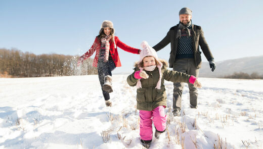 a family playing in their snow with their young child