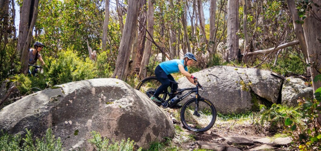 An image of two people riding mountain bikes on an outdoor trail